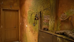A reception area with a wooden door, a reception desk, and a wall mural. - Xenonas Drimos (Karpenisi)