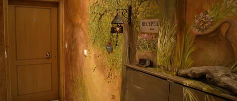 A reception area with a wooden door, a reception desk, and a wall mural.