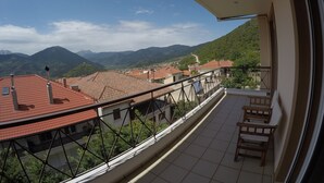 A balcony with a view of a town and mountains. - Xenonas Drimos (Karpenisi)