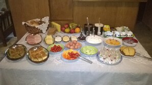 A table with various food items and condiments, including fruits, cheeses, and bread. - Xenonas Drimos (Karpenisi)