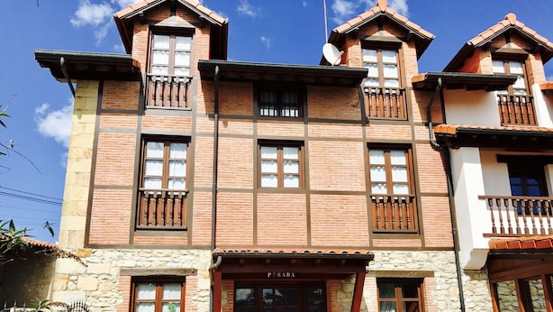 A traditional building with a stone facade, multiple windows, and a wooden door.