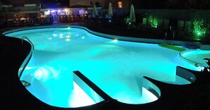 A swimming pool with a unique guitar-shaped design, surrounded by lounge chairs and umbrellas. - Macedon (Thasos)