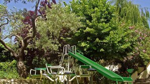 Een speeltuin met een glijbaan en schommels in een park.
