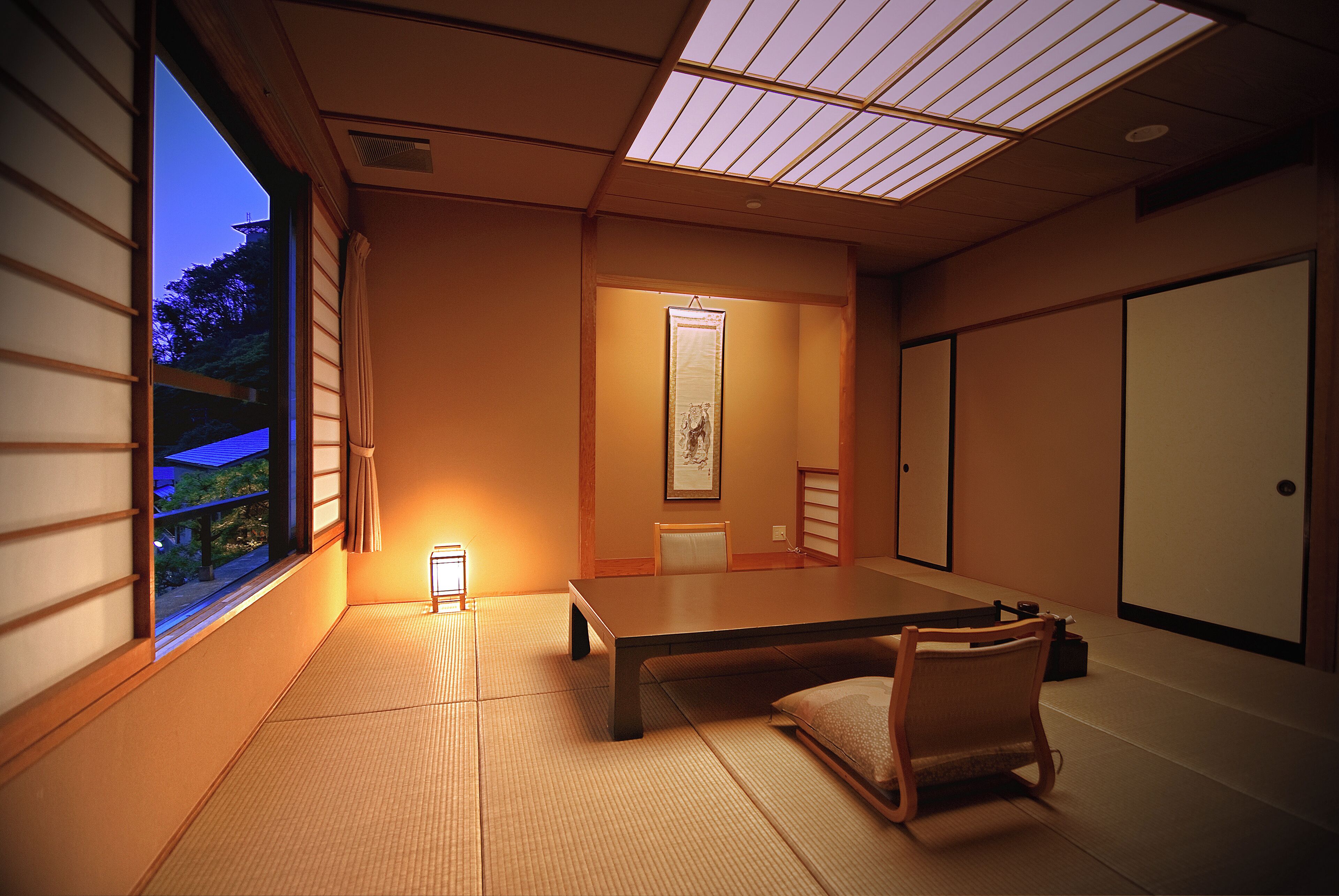 Een traditionele Japanse kamer met tatami vloerbedekking, een lage tafel en een schuifdeur.