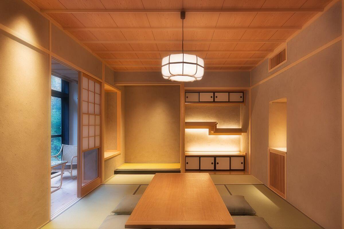 Ein traditioneller japanischer Raum mit Tatami-Bodenbelag, einem niedrigen Holztisch und Schiebetüren.