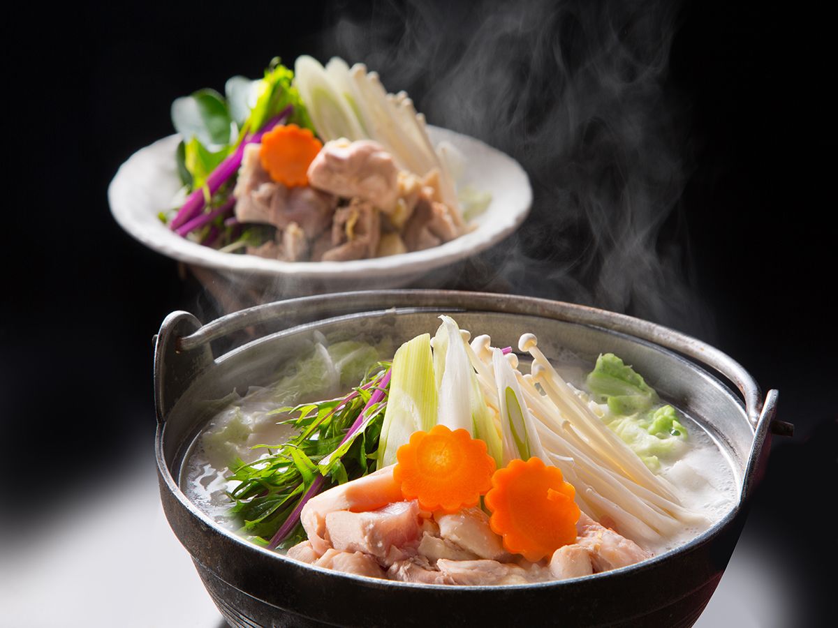 Two bowls of hot soup with vegetables and meat, steam rising from the bowls.