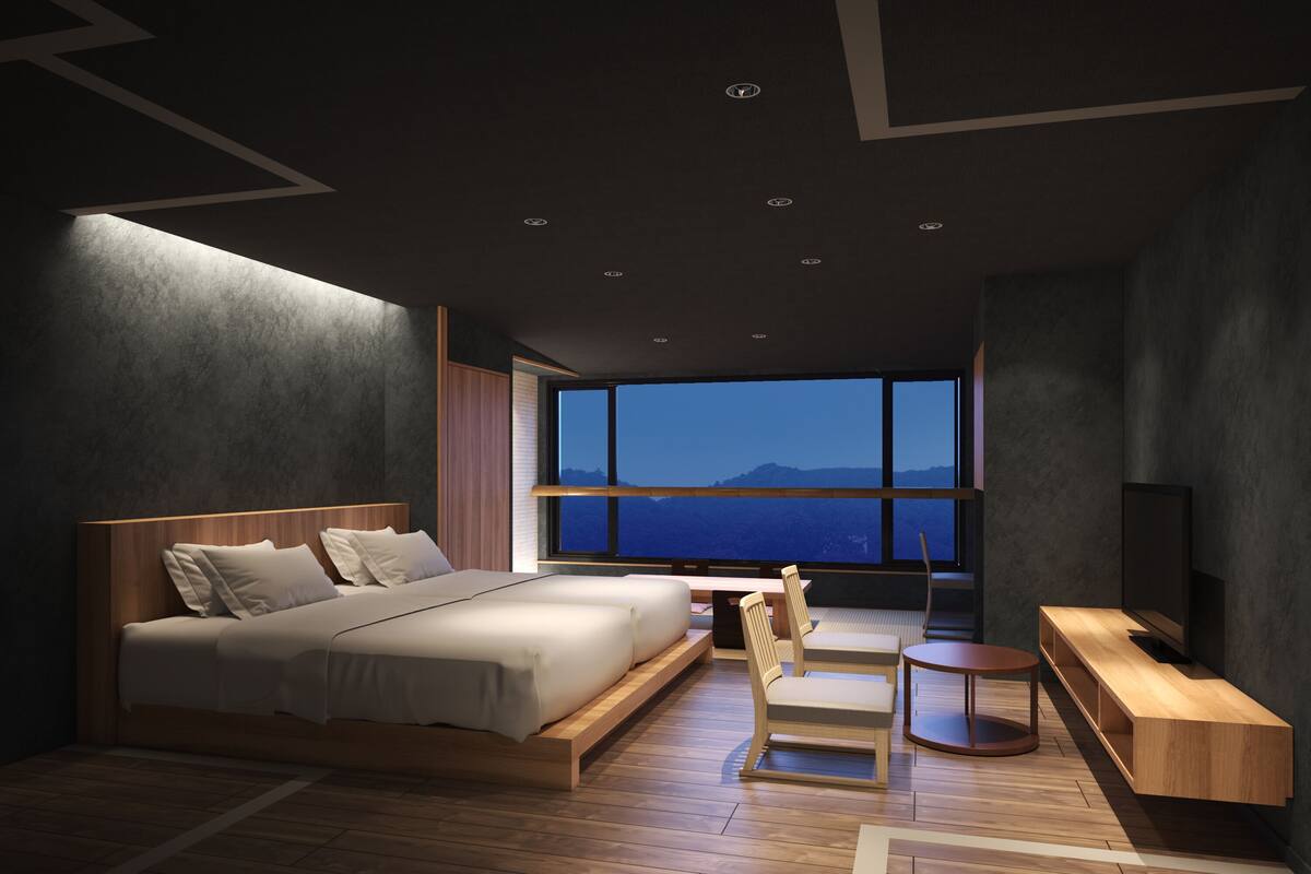 Ein modernes Schlafzimmer mit einem großen Bett, einem Schreibtisch und einem Fernseher.