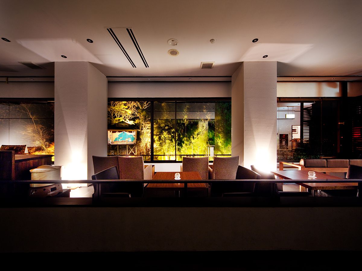A modern indoor seating area with a large window overlooking a garden, featuring a table and chairs.