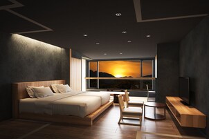 Un dormitorio moderno con una cama grande, un televisor y una ventana con vistas a la puesta de sol.