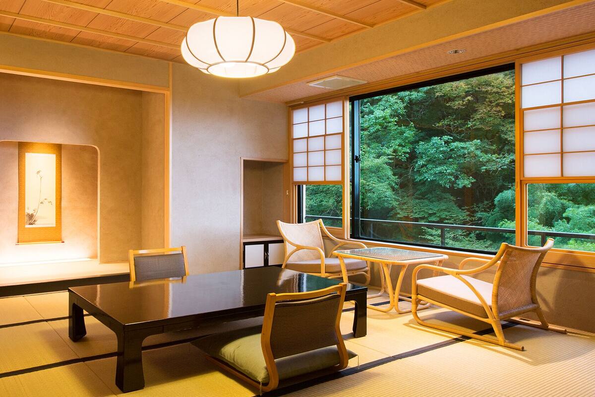 Ein traditioneller japanischer Raum mit Tatami-Boden, einem niedrigen Tisch und Stühlen.