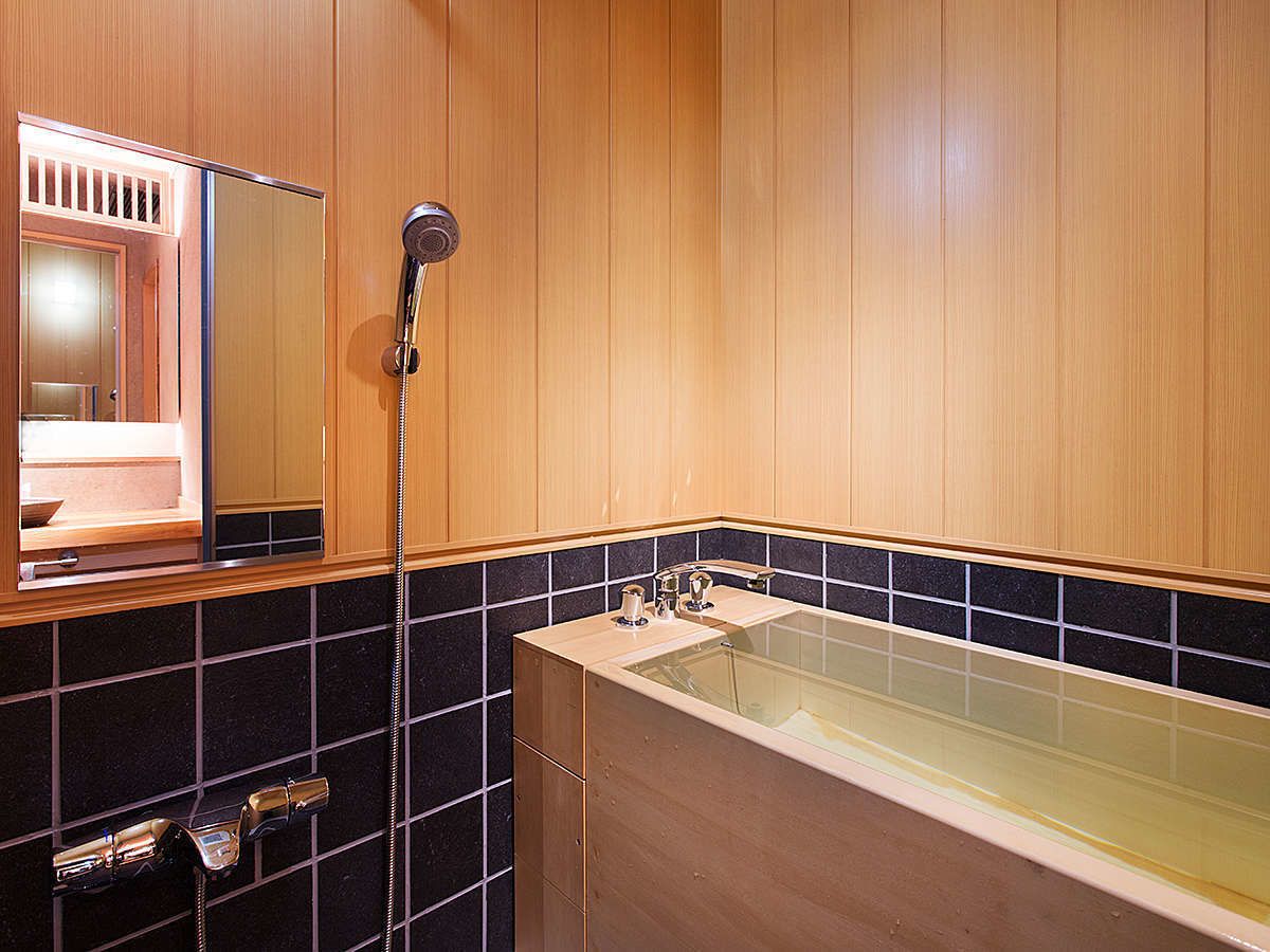 A bathroom with wooden paneling, a bathtub, a shower, and a mirror.