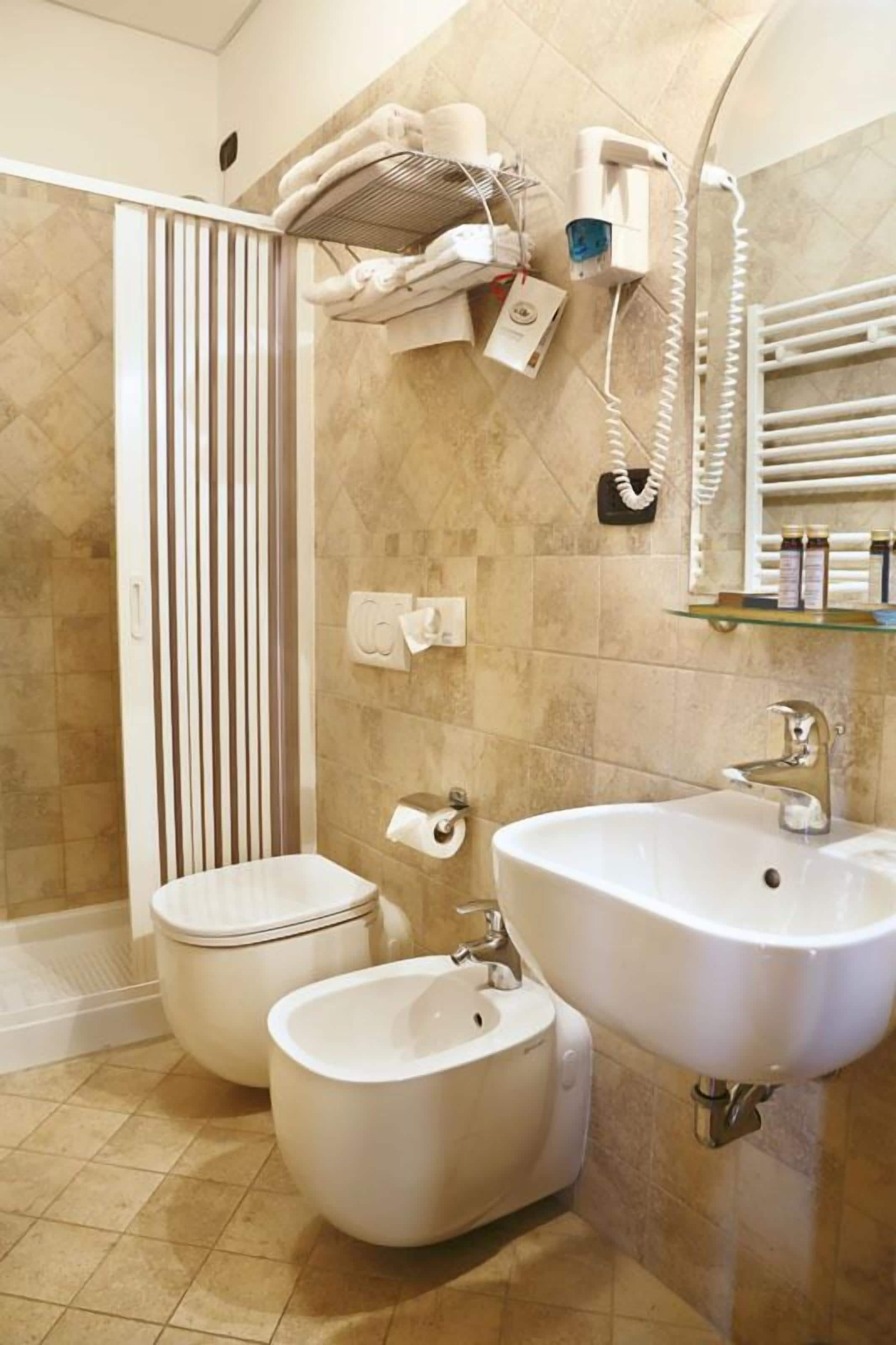 Un baño con dos lavamanos, inodoro y zona de ducha.