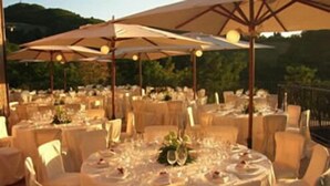 A formal outdoor dining area with round tables and chairs, covered by large umbrellas. - Colleverde Country House Beauty&Wellness (Urbino)