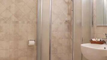 Ein Badezimmer mit Duschkabine, Toilette und Waschbecken.