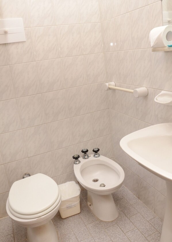 Un baño con inodoro, lavabo y bidé.