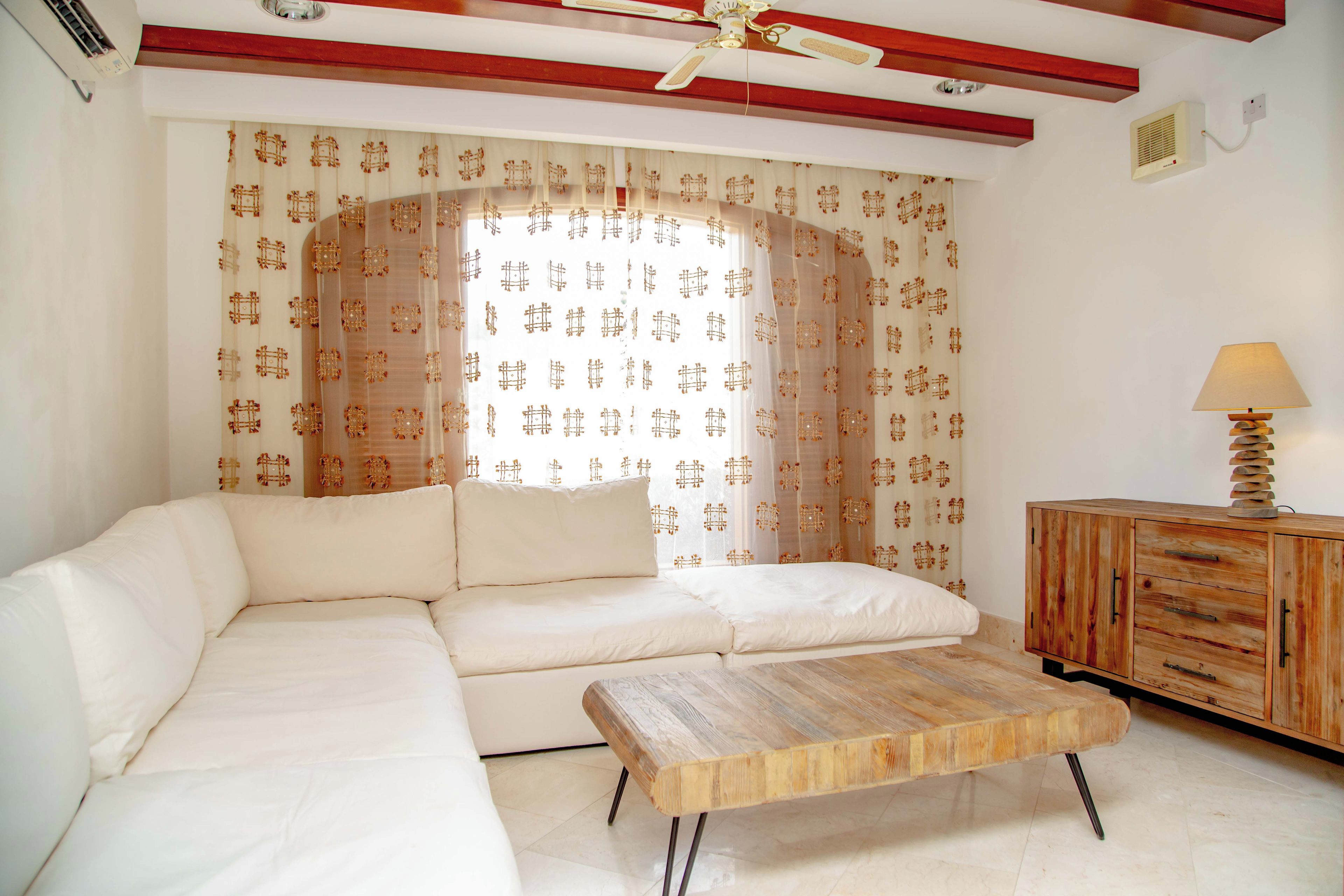 Una sala de estar con un sofá, una mesa de centro de madera y un mueble.