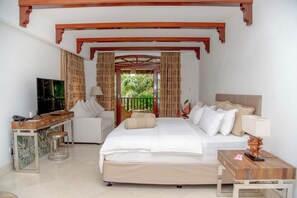 Une chambre d’hôtel avec un lit, un bureau, une télévision et une fenêtre avec des rideaux.