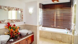 A bathroom with two sinks, a large mirror, and a bathtub. - Village du Pecheur (Praslin Island)