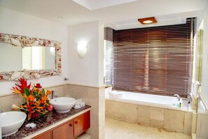 A bathroom with two sinks, a large mirror, and a bathtub. - Village du Pecheur (Praslin Island)
