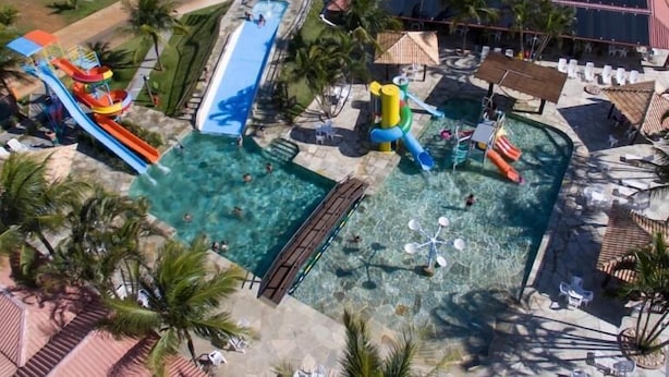 A resort with a large swimming pool, water slides, and a beach area. - Pousada Vivá (Chapada dos Guimarães)