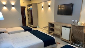 A hotel room with two beds, a TV, a desk, and a wardrobe. - Pousada Vivá (Chapada dos Guimarães)