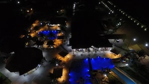 An aerial view of a resort with a swimming pool, lounge areas, and a covered pavilion. - Pousada Vivá (Chapada dos Guimarães)