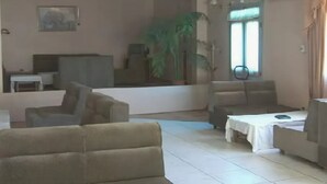 Un saló amb sofàs beix, una taula petita i una planta en test.