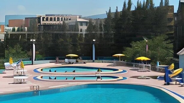 Zona de piscina amb diverses piscines, gandules i para-sols.