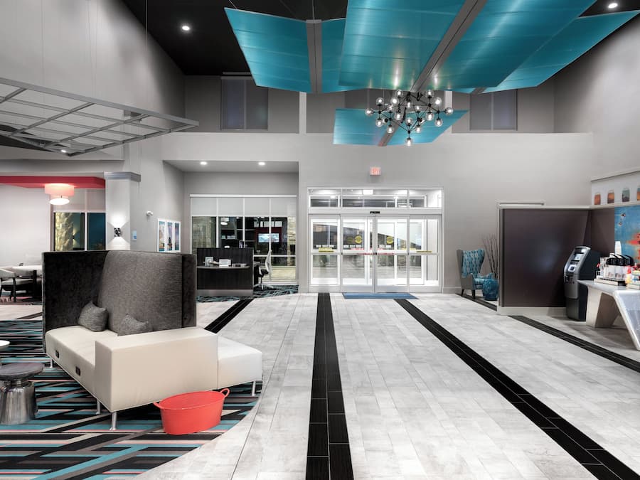 A modern lobby with a reception desk, seating area, and a coffee station.