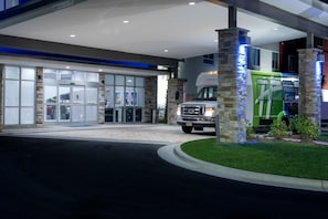 A hotel entrance with a clearway sign, a truck, and a Holiday Inn Express sign.
