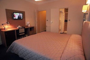 A hotel room with a bed, a desk with a lamp, a television, and a walk-in closet. - Inter-hotel MPL Ouest Hôtellerie de Balajan (Vic-la-Gardiole)