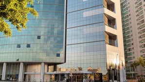 A modern hotel with a curved glass facade, labeled "Windsor," and a visible entrance with a sign. - Windsor Brasilia Hotel (Brasília)