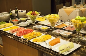 Ein reichhaltiges Buffet mit Obst, Gemüse und Fleisch.