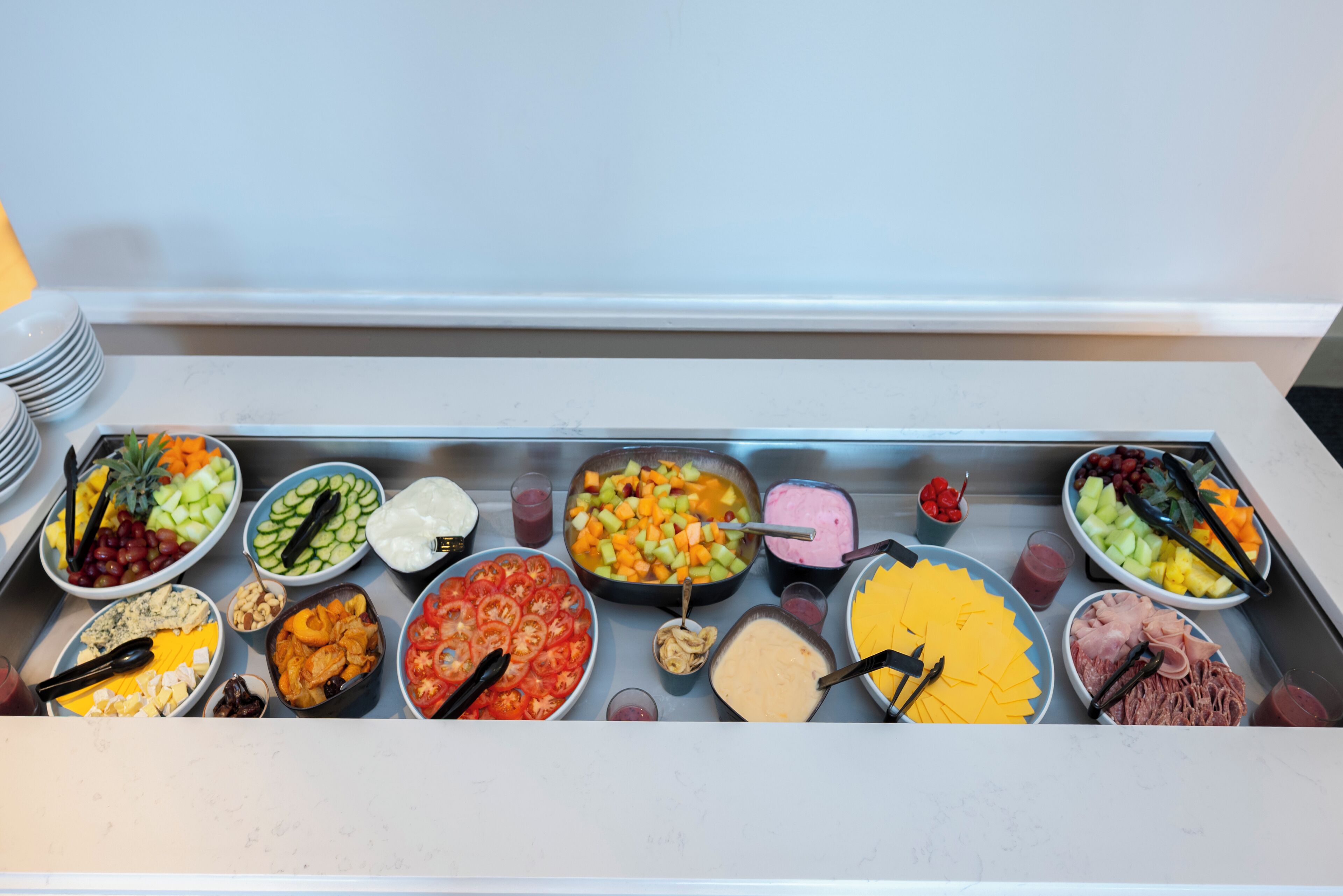 Una mesa de buffet con diversos alimentos y utensilios.