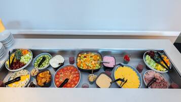 Una mesa de buffet con diversos alimentos y utensilios.