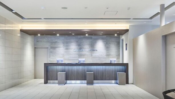 A reception area with a marble wall, a reception desk, and two speakers. - Daiwa Roynet Hotel Tokyo Akabane (Tokyo)