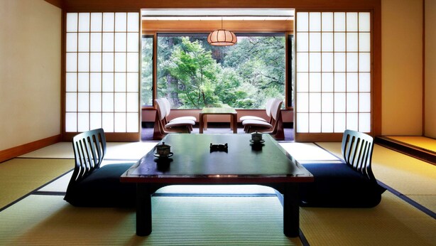 A traditional Japanese room with tatami flooring, a low table, and sliding doors.