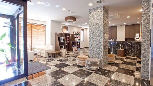 A hotel lobby with a checkered floor, seating area, and a reception desk. - Kuretake Inn Premium Shizuokaekimae (Shizuoka)
