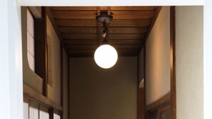 Un pasillo estrecho con piso de madera y puertas correderas tradicionales.