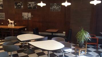 A restaurant with checkered flooring, modern chairs, and pendant lighting.