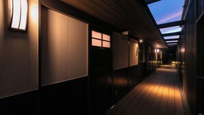 A corridor with wooden flooring, recessed lighting, and a skylight.