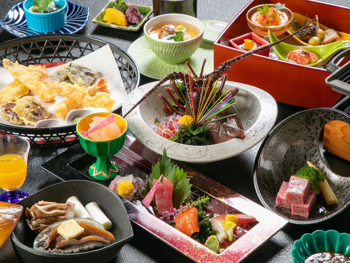 Diversidad de platos japoneses, como tempura, sashimi y preparaciones a la parrilla, presentados en una mesa con múltiples cuencos y fuentes.