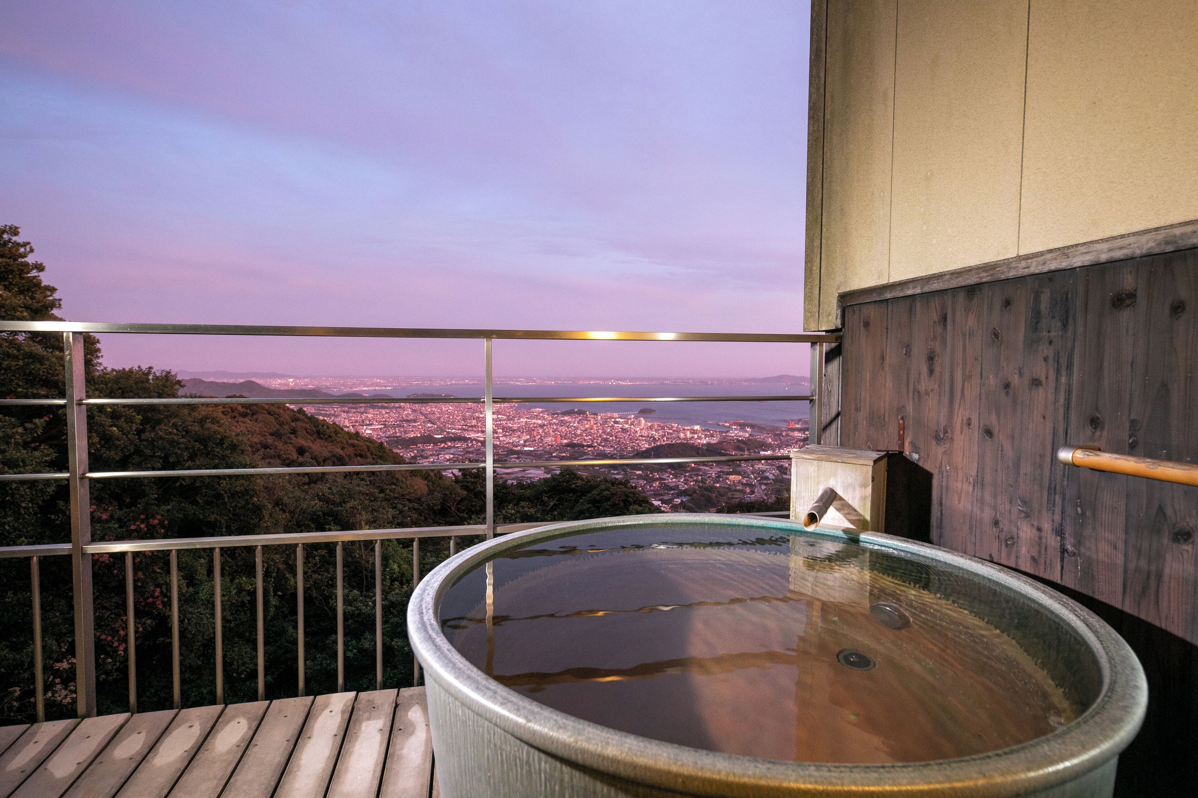 Un jacuzzi en un balcón con vistas a la ciudad.