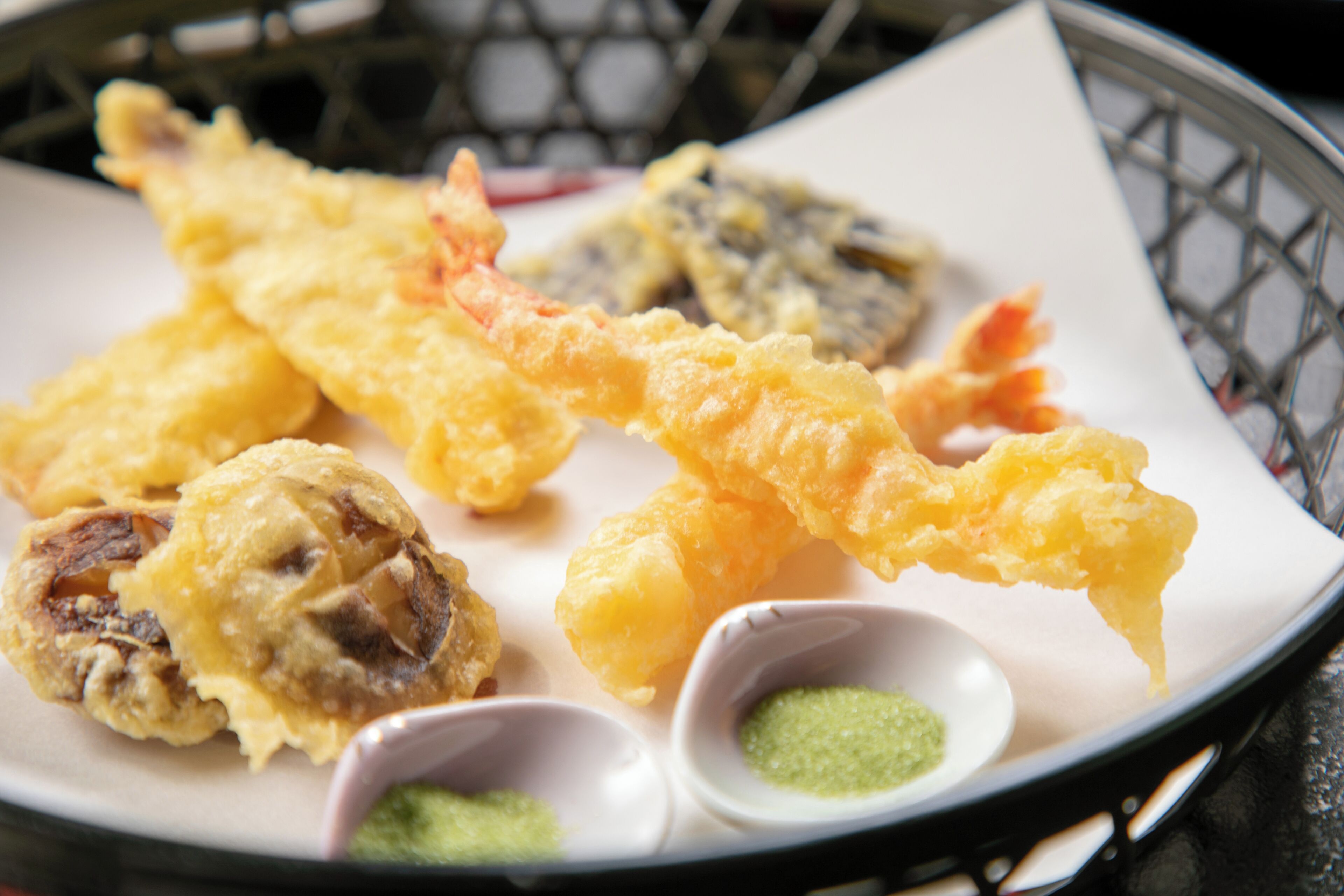 Un plateau de beignets japonais (tempura) accompagnés de sauces pour tremper.