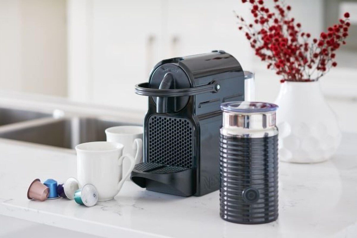 Una encimera de cocina con una cafetera, un dispensador de agua y un termo.