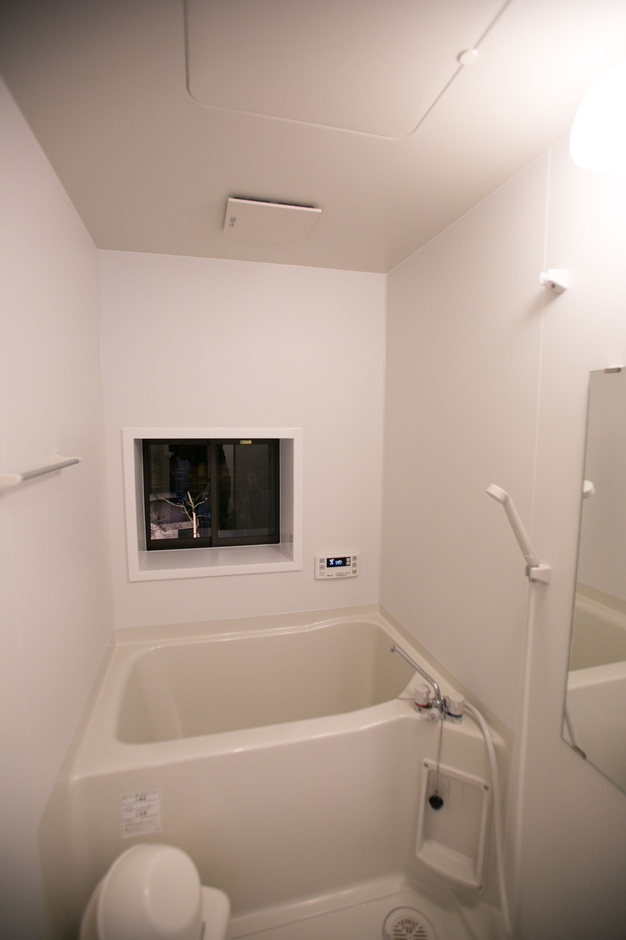 Une salle de bain avec une baignoire, une fenêtre, des toilettes et une douche.