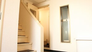 Una escalera que lleva a un rellano con una puerta y una ventana.