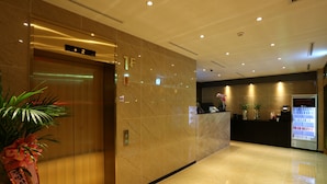 A hotel lobby with a reception desk, a vending machine, and an elevator. - W Hotel (Incheon)