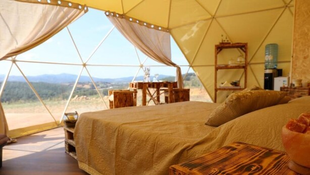A tented accommodation with a bed, wooden furniture, and a view of the outdoors. - Azienda Agricola Pietra Serena B&B (Civitella Paganico)