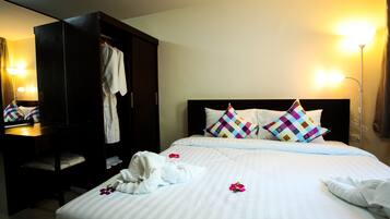 A hotel room with a bed, a wardrobe, and a mirror.